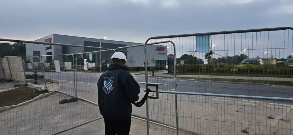 Security officer unlocking a controlled site entrance while serving a Norwich client