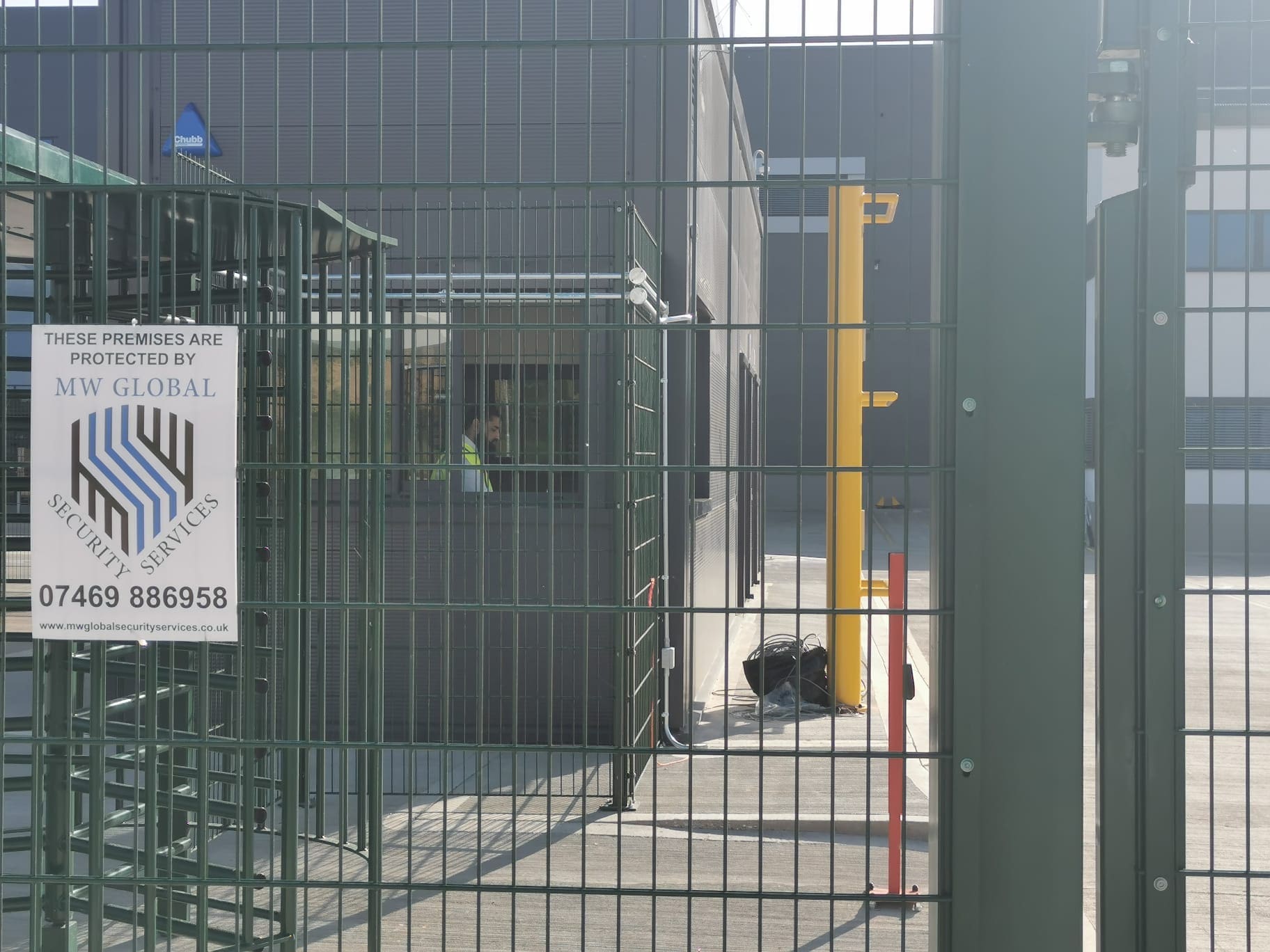 Gatehouse security entrance with controlled access barriers and secure perimeter fencing