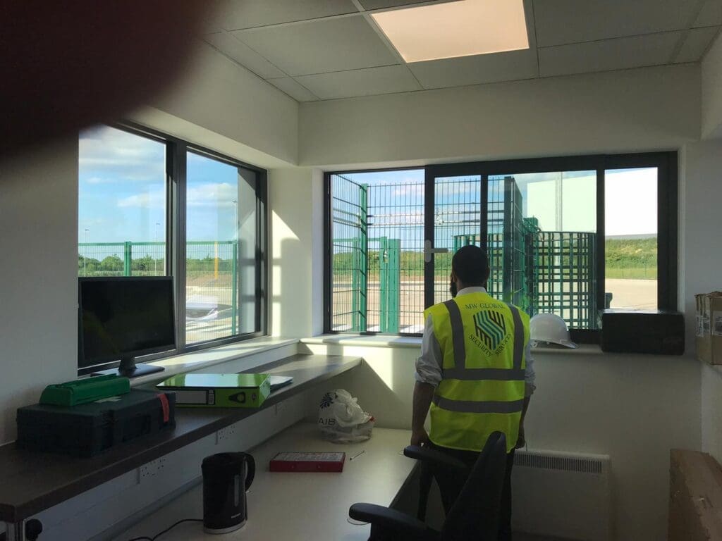 Security officer providing gatehouse access control at a commercial site